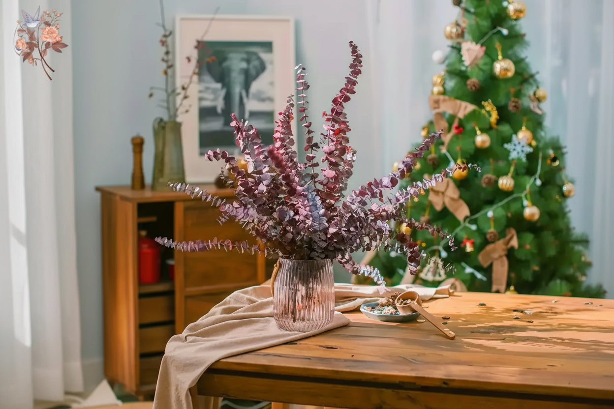Decorative plant in a vase on a table with a Christmas tree in the background